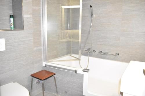 a shower in a bathroom with a toilet and a stool at Allod 284 Ba (Whg. Nr. 506) in Lenzerheide
