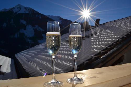 dwa kieliszki szampana siedzące na stole z widokiem w obiekcie Apart Spitaler Brandberg w mieście Brandberg