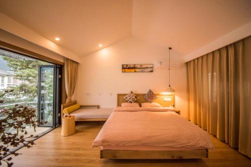 a bedroom with a bed and a large window at Dali Dream House with Seaview in Dali