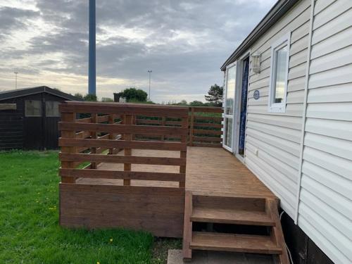 a wooden deck on the side of a house at Mobilhome (29) 4 pers St Martin aux Buneaux in Saint-Martin-aux-Buneaux