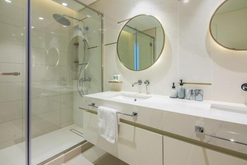 uma casa de banho com um chuveiro, um lavatório e um espelho. em 2BR Amazing Palm View - Private beach - Beach Vista T1 em Dubai
