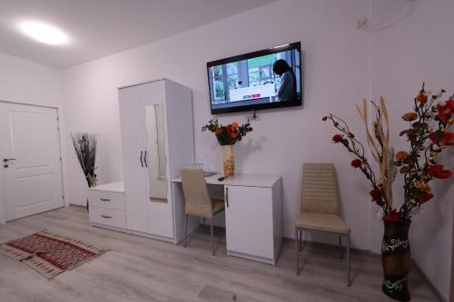 Habitación con escritorio y TV en la pared. en Casa Cojocaru, en Cîrcea