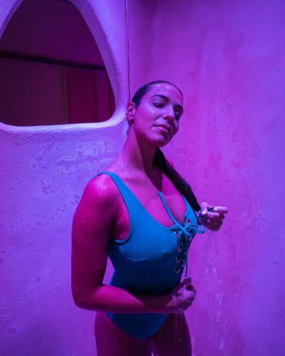 a woman standing in front of a purple wall at Hotel & Spa Relais Freedom Club in Massa Lubrense