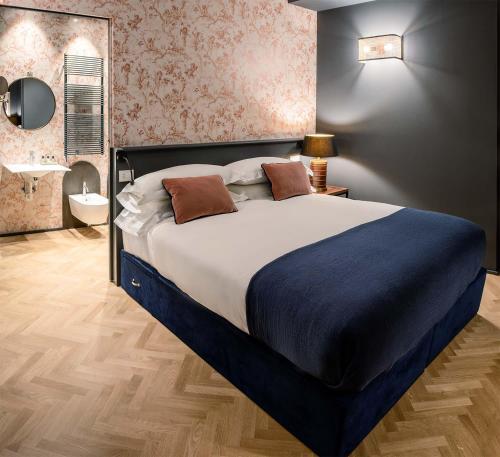 a bedroom with a large bed and a bathroom at Bellacorte Gentiluogo per Viaggiatori in Parma