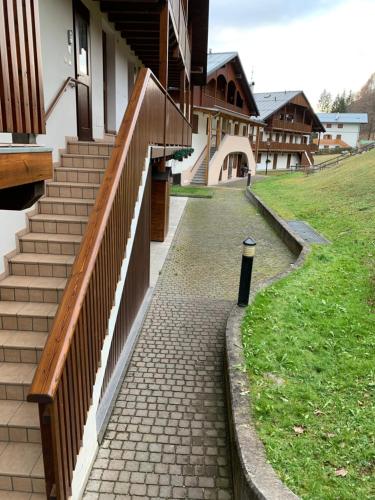 a brick walkway next to a building with stairs at Casa Francesca - Relax nel cuore delle Dolomiti in Pieve di Cadore