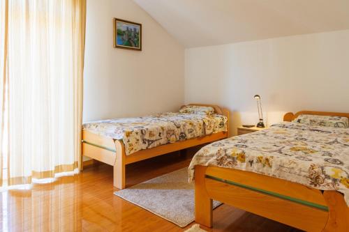 a bedroom with two beds and a window at Prenoćište Jorgovan in Golubac