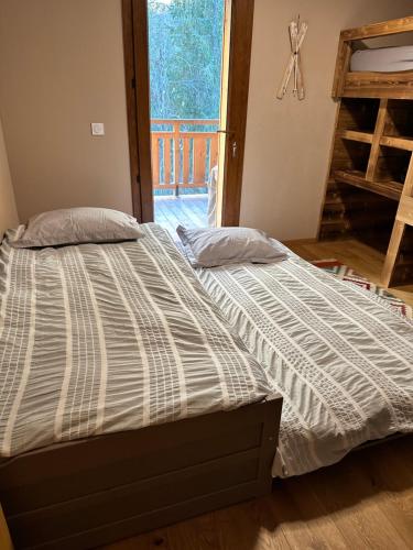 a bed sitting in a room with a window at Gorgeous 2 bedroom, 2 full bath, ski in apartment! in Morzine