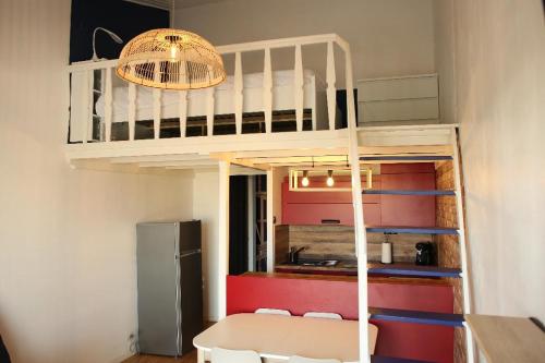 Cette petite chambre comprend des lits superposés et une table. dans l'établissement Studio vue sur mer, à La Chaume