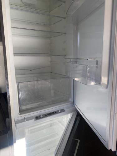 an empty refrigerator with its door open and its empty drawer at Today Appartement in Chippis