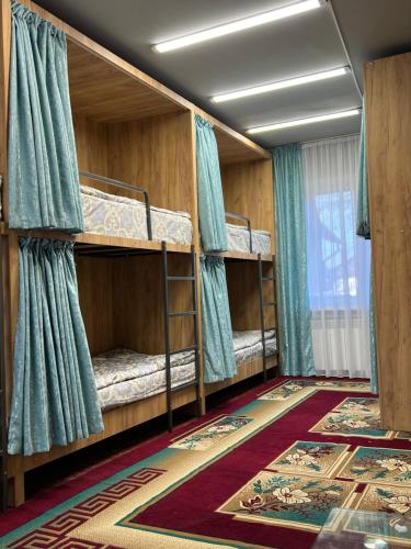 Zimmer mit 4 Etagenbetten und einem Teppich in der Unterkunft Hostel Edem Bishkek in Tokolʼdosh