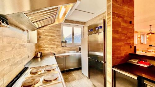 a kitchen with a stainless steel refrigerator and a sink at Hostel C'est la Vie in Hasliberg