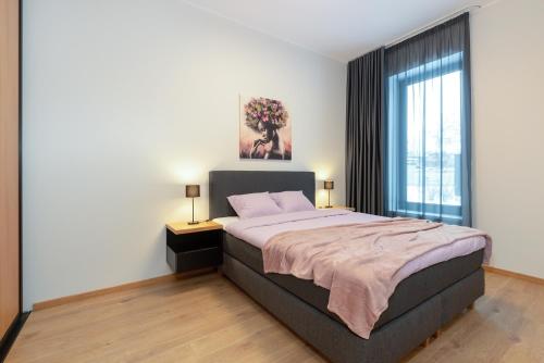 een slaapkamer met een bed en een groot raam bij TartuKodu Riia20A-8 in Tartu