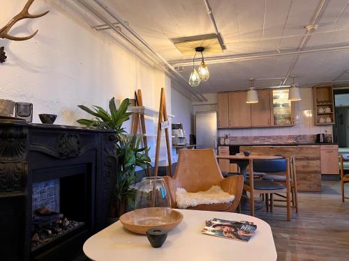 a living room with a fireplace and a table at Hostel C'est la Vie in Hasliberg