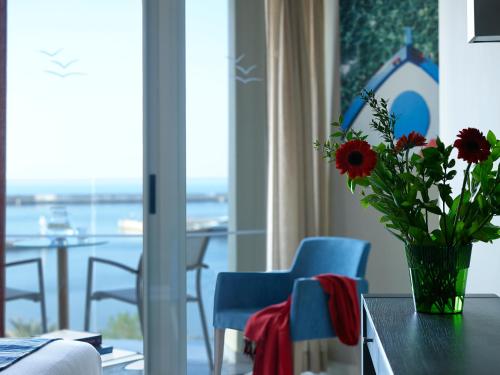 a vase of flowers sitting on a table in a living room at Kyma Suites Beach Hotel in Rethymno Town