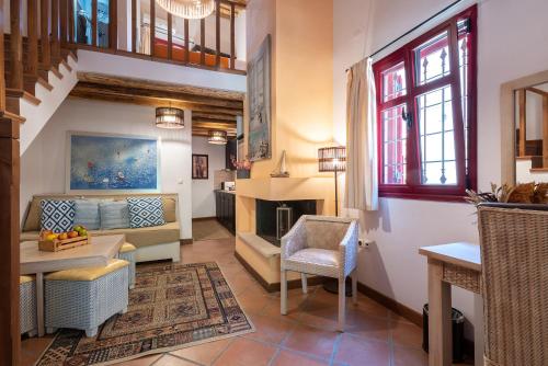 ein Wohnzimmer mit einem Sofa und einem Kamin in der Unterkunft The Varos Residences Hotel in Város