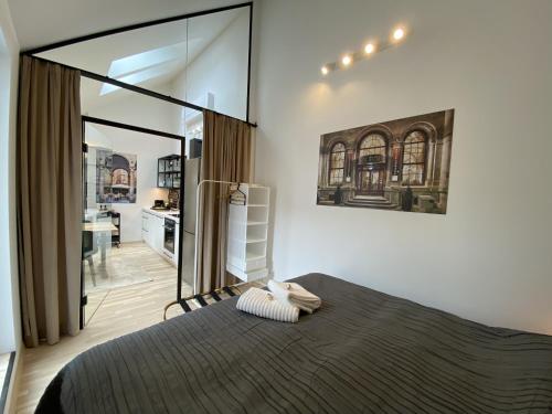 a bedroom with a large bed and a kitchen at Stilvolle Dachgeschosswohnungen mit Balkon in Innenstadt Nähe in Vienna