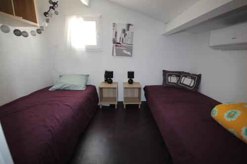 une chambre avec deux lits et une fenêtre dans l'établissement Maison d'angle climatisée dans résidence avec piscine commune , 4 couchages , 400 m de la plage de PORTIRAGNE LRJP121, à Portiragnes