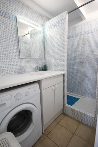 La salle de bains est pourvue d'un lave-linge et d'une douche. dans l'établissement Maison d'angle climatisée dans résidence avec piscine commune , 4 couchages , 400 m de la plage de PORTIRAGNE LRJP121, à Portiragnes
