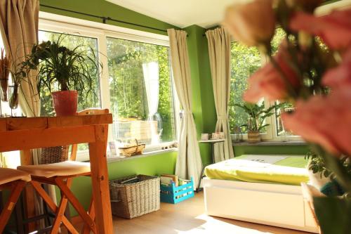 Habitación con cama y ventana con plantas. en Chez Madame Irma en Aywaille