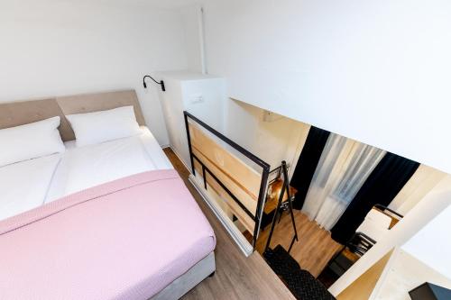 a small bedroom with a bed and a staircase at Adagio Downtown Rooms in Budapest