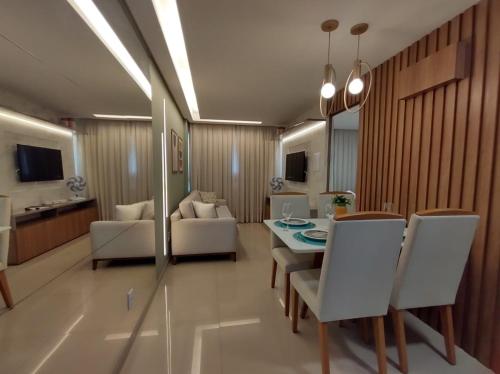 a living room with a table and white chairs at Rio Park Avenue Residence, Piedade - By TRH Invest in Recife