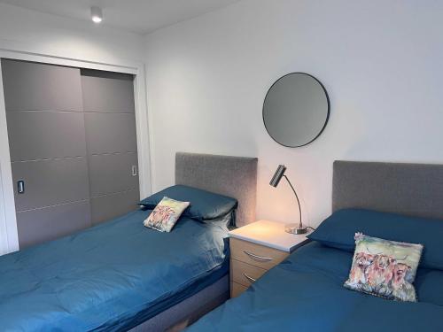 a bedroom with two beds and a mirror on the wall at Caledonia Place in Aviemore