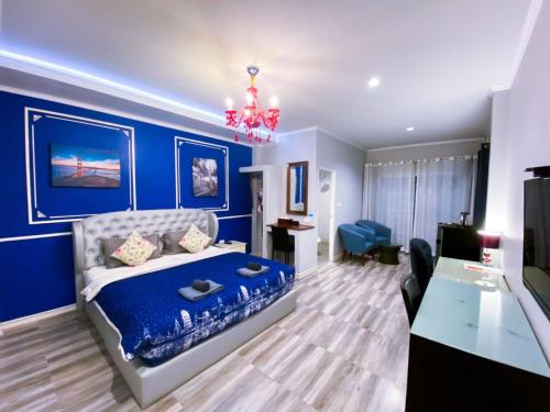 a blue bedroom with a bed and a desk at Aen Guy Boutique Hotel in Sukhothai