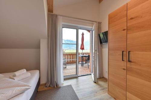 een slaapkamer met een bed en een deur naar een balkon bij Landhaus am See Appartement LH 05 in Schwangau