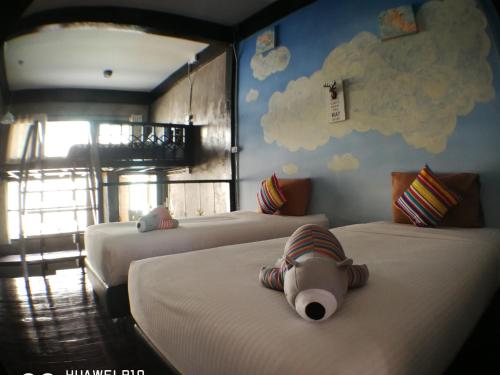 a bedroom with two beds with a teddy bear on the bed at Aen Guy Boutique Hotel in Sukhothai