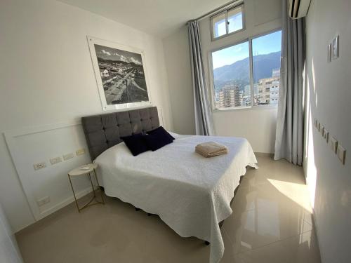1 dormitorio con cama y ventana grande en Duas suítes Leblon a duas quadras da praia, en Río de Janeiro