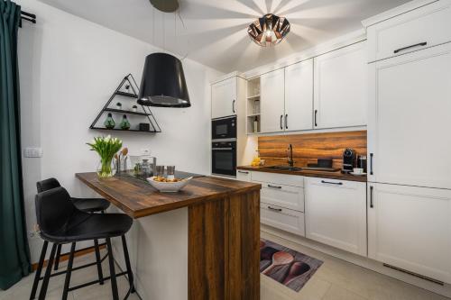 a kitchen with white cabinets and a wooden counter top at Villa Oliva Muntrilj in Muntrilj