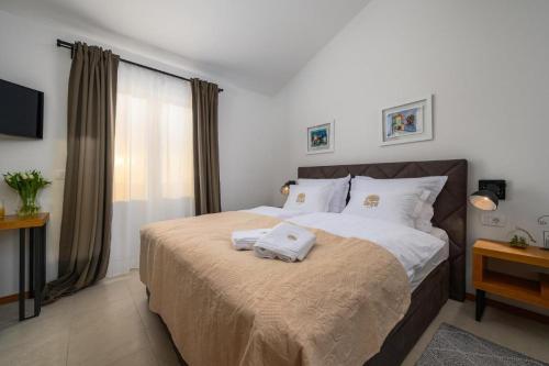 a bedroom with a bed with two towels on it at Villa Oliva Muntrilj in Muntrilj