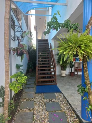 a stairway in a house with plants and a staircase at Pousada Char in Ubatuba