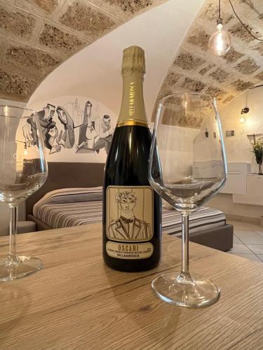 阿尔盖罗POMA DE CASA - Carrerò del Carmen的桌上放着一瓶葡萄酒和两只酒杯