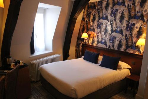 a hotel room with a bed with a floral wallpaper at Best Western de Diane in Nevers