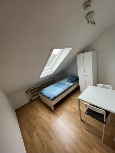 Schlafzimmer mit einem Bett, einem Schreibtisch und einem Fenster in der Unterkunft Zentral gelegene Apartments am Schillerplatz in Mönchengladbach