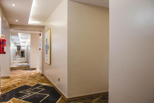 a hallway with white walls and a painting on the wall at AMBER CITY HOTELS in Owerri