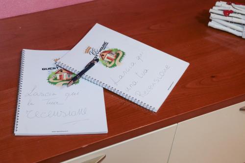 a table with two pieces of paper and a pen at Guest House Romero in Cadelbosco di Sotto