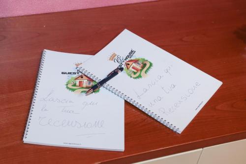 a table with two pieces of paper and a pen at Guest House Romero in Cadelbosco di Sotto