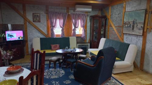 a living room with a table and chairs and a tv at Vikendica Jelena in Mionica