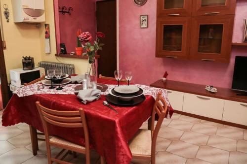 a kitchen with a table with a red table cloth at Guest House Romero in Cadelbosco di Sotto