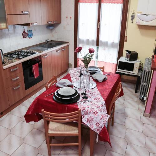 a kitchen with a table with a red table cloth at Guest House Romero in Cadelbosco di Sotto