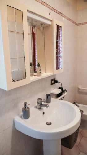 a bathroom with a white sink and a mirror at Guest House Romero in Cadelbosco di Sotto