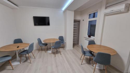 a room with two tables and chairs and a tv at Vila Central in Constanţa