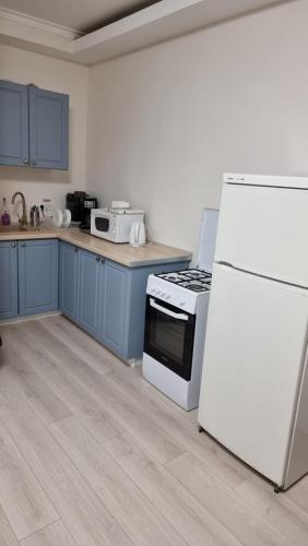 a kitchen with blue cabinets and a white refrigerator at Vila Central in Constanţa