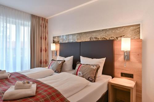 a hotel room with two beds and a large window at Monusse Boid Wohnung 15 in Pfronten