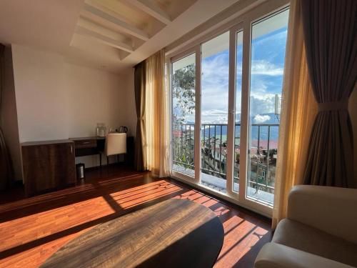 a living room with a large window with a view at Magpie Libing Grand (MG Marg) in Gangtok