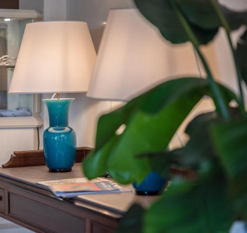 a blue vase sitting on a table next to a lamp at Hotel Anthony in Lido di Jesolo