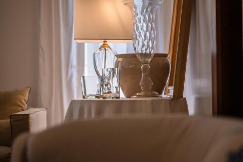 una mesa con una lámpara y un jarrón de cristal. en Hotel Anthony, en Lido di Jesolo