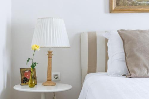a lamp on a side table next to a bed at Skopelos Village Hotel in Skopelos Town